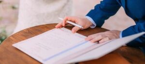 Regimes de bens: Homem segurando caneta para assinar casamento civil
